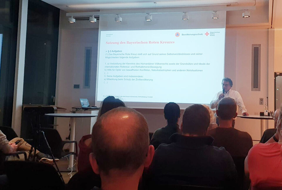 P5-Fortbildung 2 Menschen in Sitzreihen mit Blick auf eine Leinwand